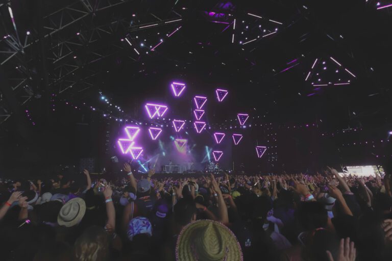 Festival crowd beneath neon stage lighting in the California Desert